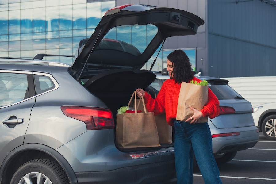 Satisfied click and collect customer puts order in trunk