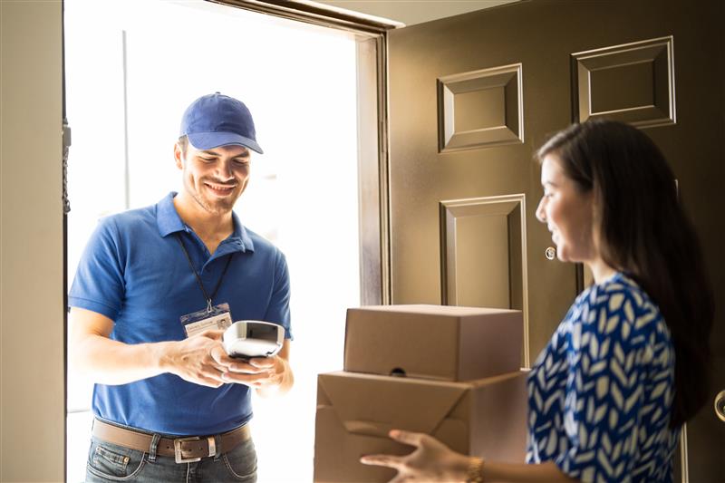 Female customer accepts packages from delivery driver