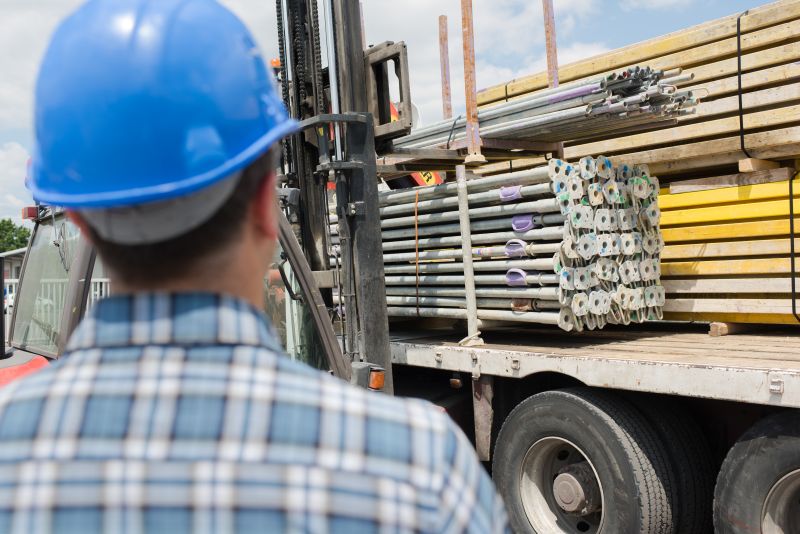 Construction workers observes building materials on flatbed truck